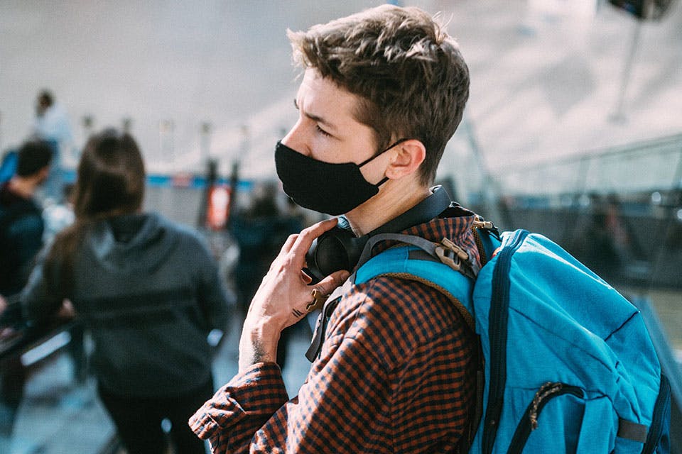 Man with mask and backpack traveling