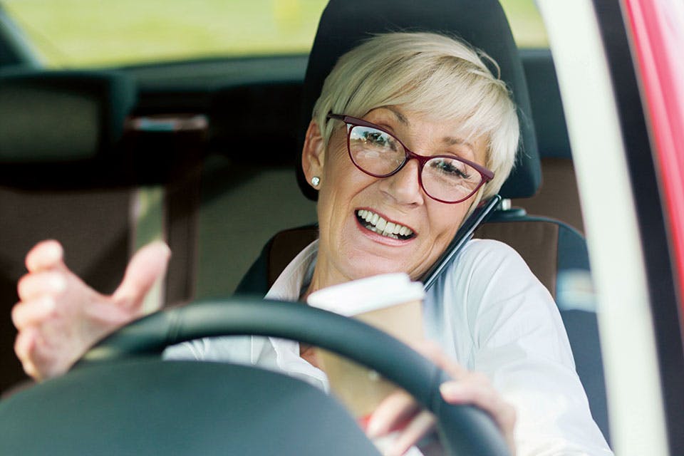 Woman talking on the phone and driving Woman talking on the phone and driving