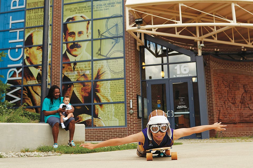 Dad and children in front of Wright Dunbar Interpretive Center & Aviation Trail Visitor Center (photo by Casey Rearick)