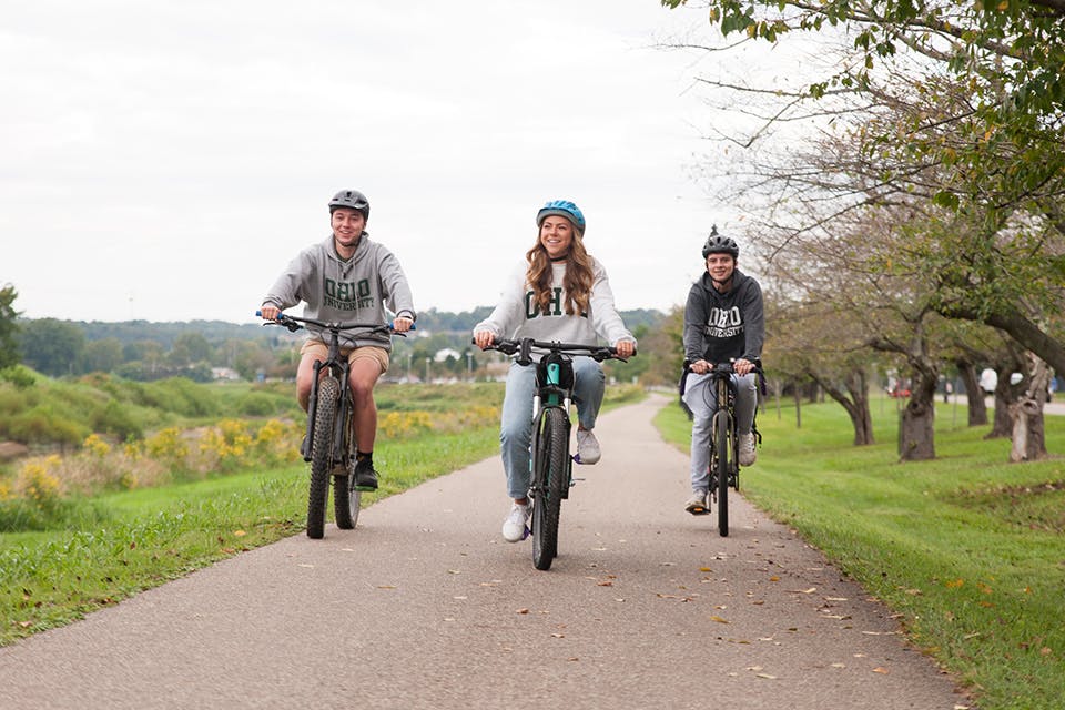 Three Ohio University students biking on Athens’ Hockhocking Adena Bikeway (photo by Michelle Waters)