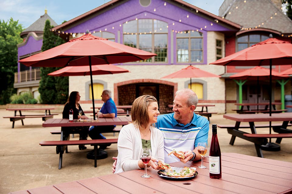 Couple drinking wine and eating pizza at Breitenbach Wine Cellars in Dover (photo by Kevin Kopanski)