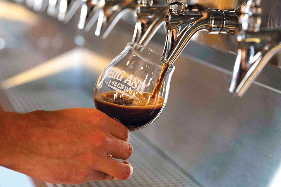 Man pouring beer from tap at Cincinnati’s Big Ash Brewing (photo courtesy of Big Ash Brewing)
