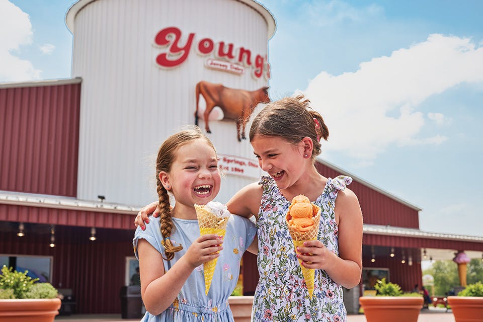 Two girls laughing and holding ice cream cones at Young’s Jersey Dairy in Yellow Springs (photo by Matt Witherspoon)