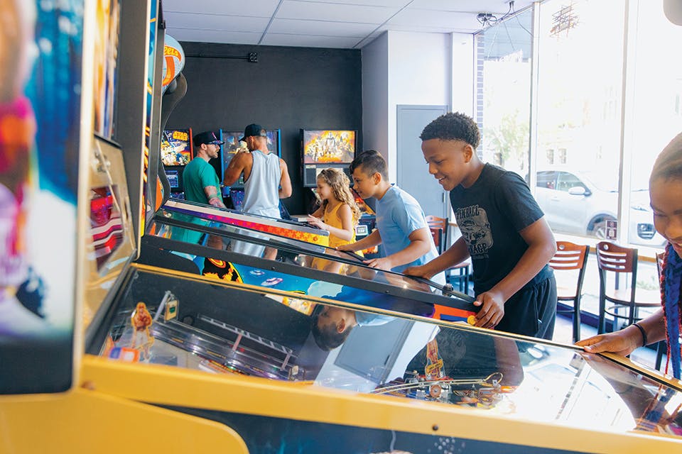 Kids playing pinball at the Pinball Garage in Hamilton (photo courtesy of Travel Butler County)
