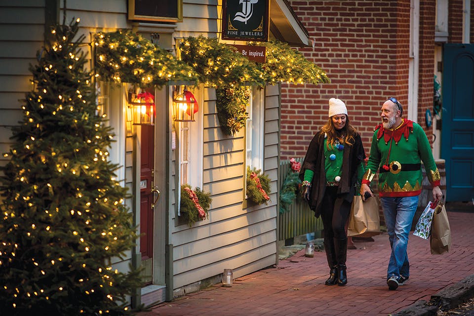 People in Christmas sweaters walking at Roscoe Village Christmas Candlelighting in Coshocton (photo courtesy of Ross Chillicothe Convention & Visitors Bureau)