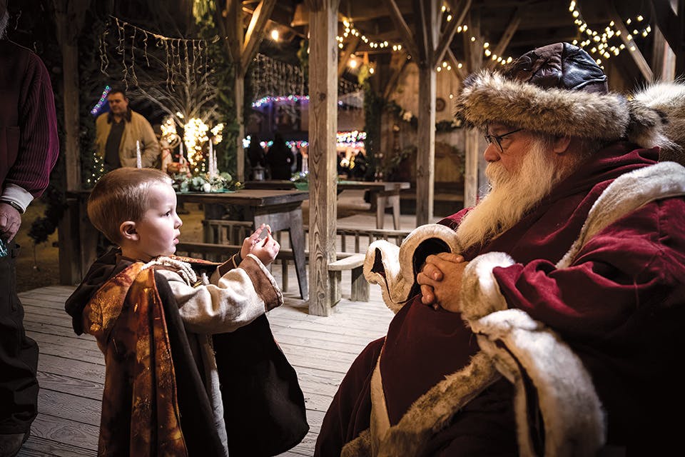 Child talking with Santa Claus at Yuletide Village in Waynesville (photo by Checkmate Photos)