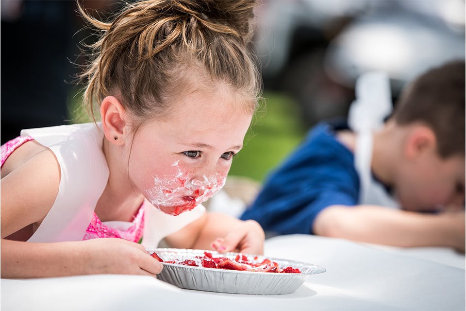 Child in strawberry pie eating contest at Troy Strawberry Festival (photo courtesy of Troy Strawberry Festival Facebook)
