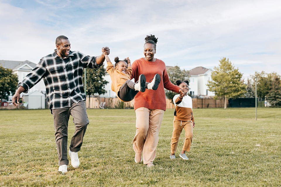 Family of four playing outside in yard (photo by iStock)