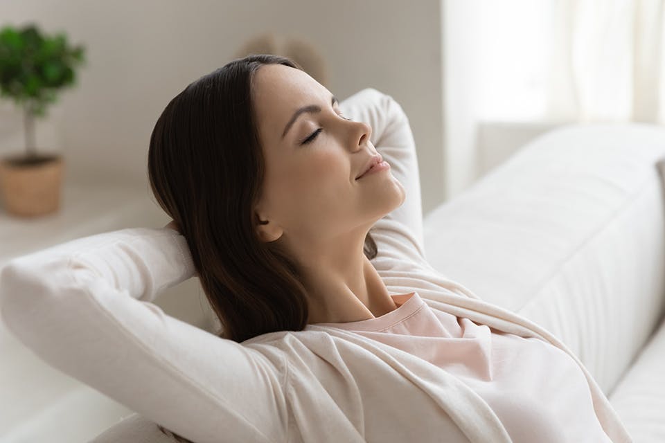 Woman relaxing and taking a deep breath (photo by iStock)