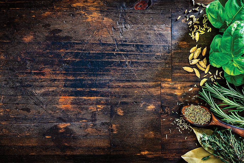 Wooden table with herbs on righthand side (photo by iStock)