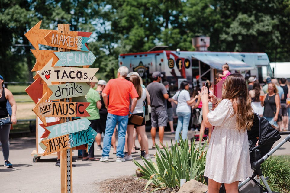 Woman taking photo of sign at 720 MKT + TACO PARTY in North Canton (photo courtesy of 720 Market)