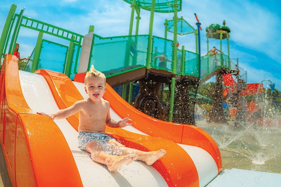 Child on water slide at Seneca Lake in Muskingum County (photo courtesy of Muskingum Watershed Conservancy District)