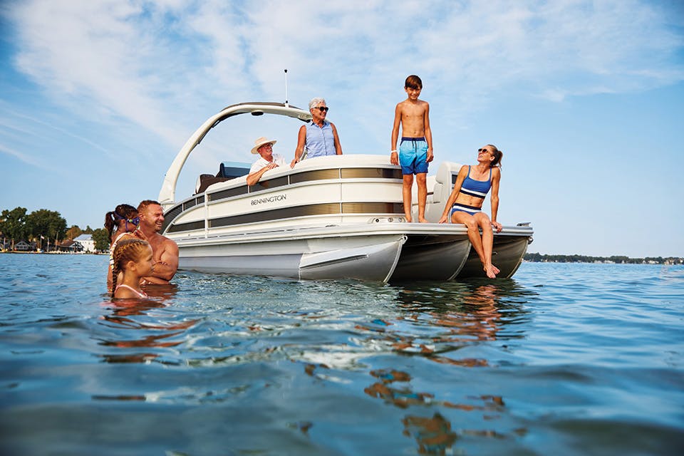 Family on a boat and in the water at Indian Lake Boat Show (photo courtesy of Logan County Visitors Bureau)